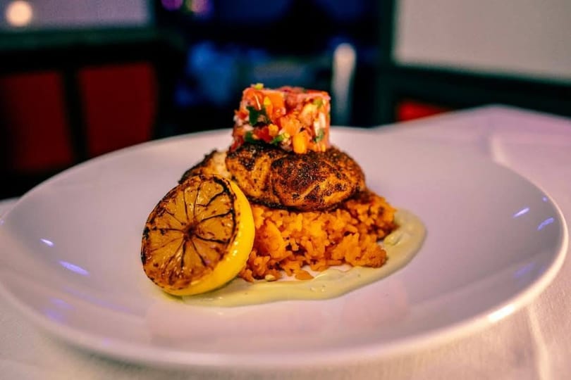 Flare House American Fusion Cuisine's blackened fish with rice, salsa, and a grilled lemon.